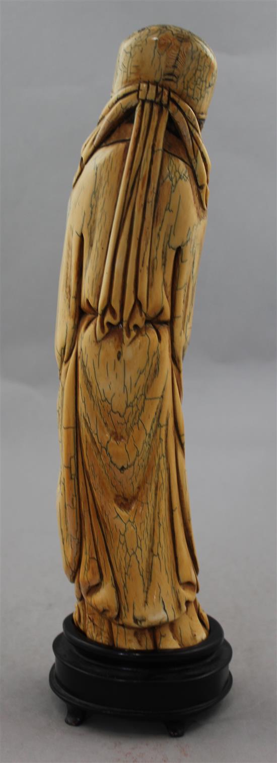 A Chinese mammoth ivory carving of an immortal, in Ming style, 20th century, 30cm, wood stand